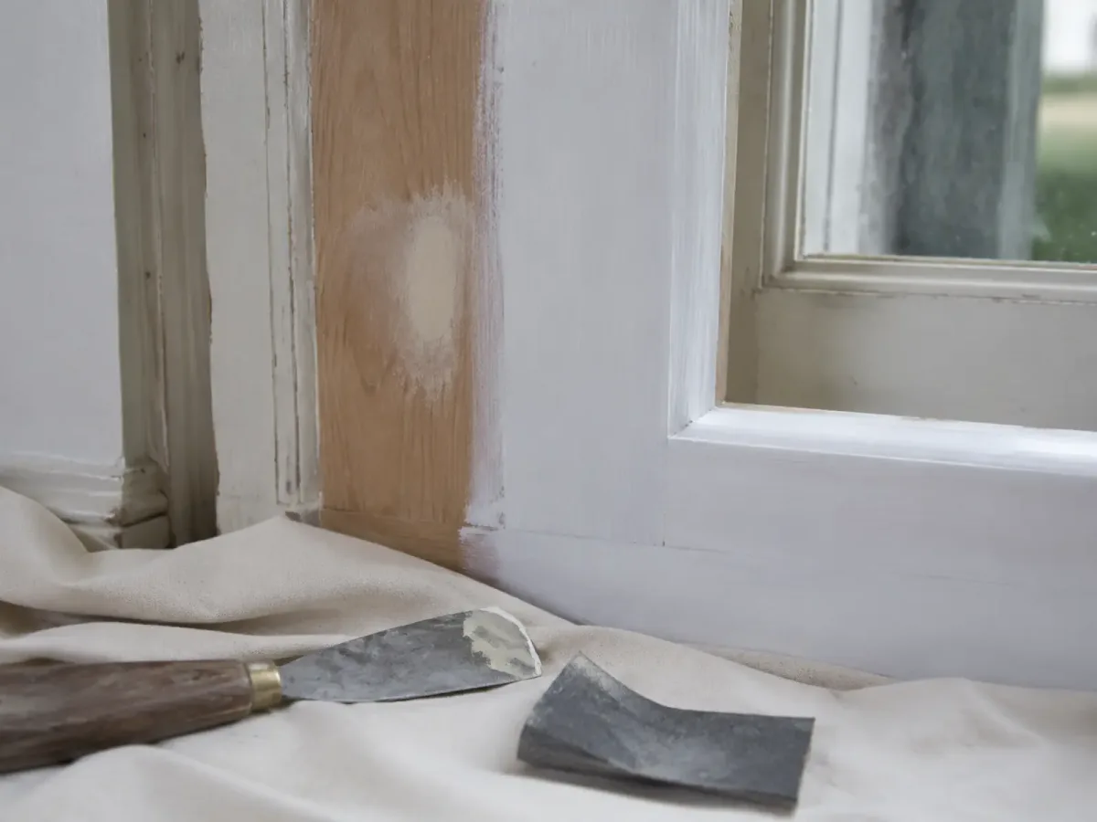 Close view of prepared timber with feathered coating edges and primed areas.